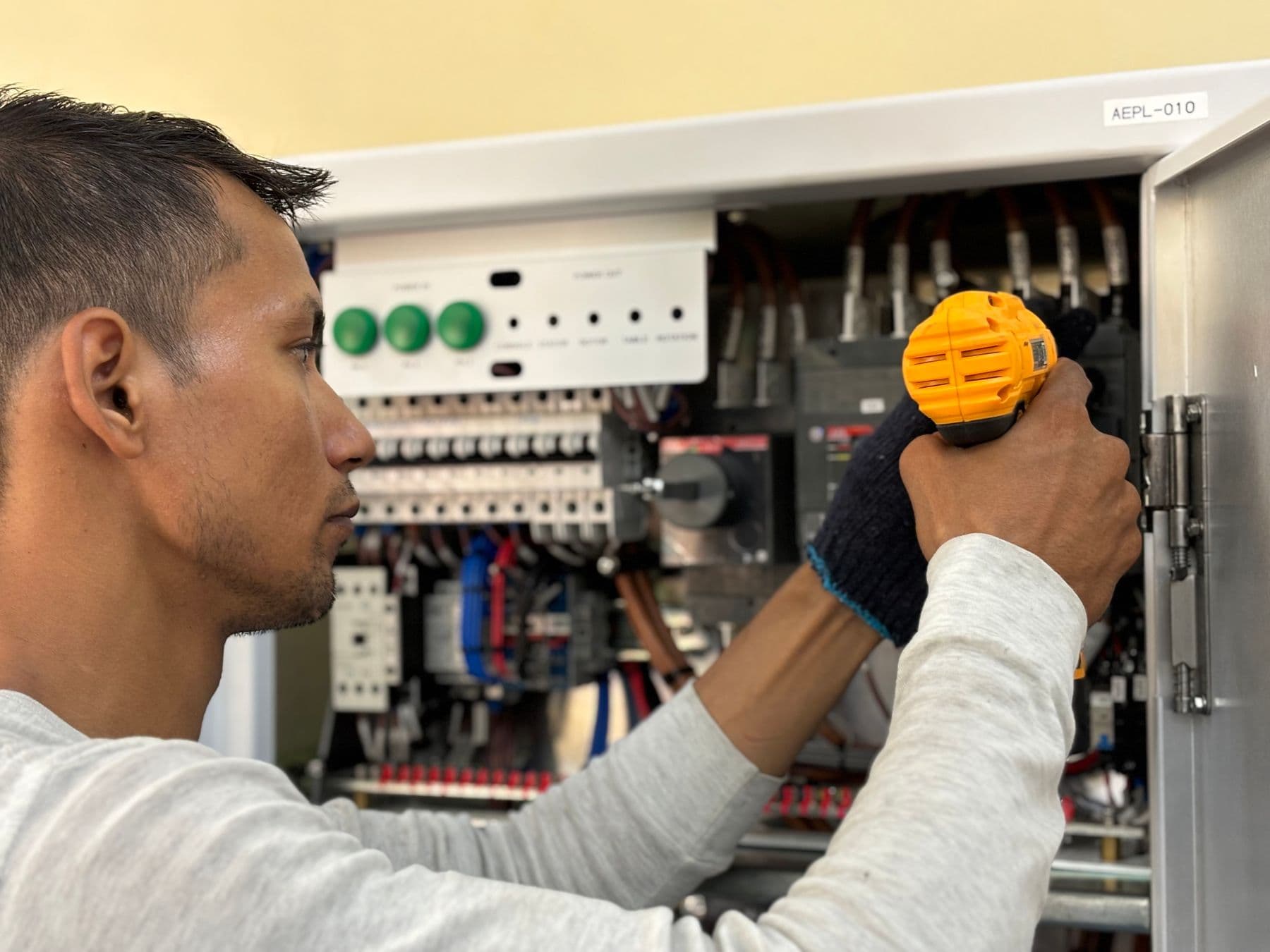 Villanyszerelő elektromos hibát hárít el szerszámmal
